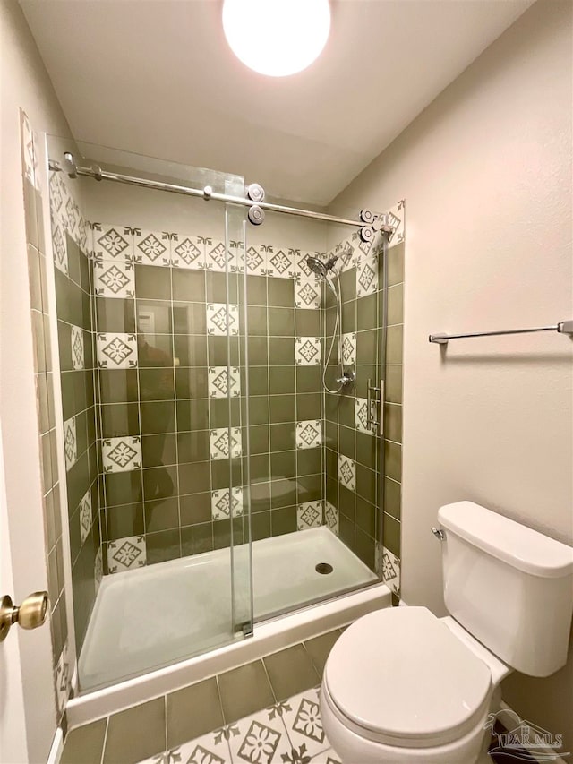 bathroom with a shower with door, tile patterned flooring, and toilet