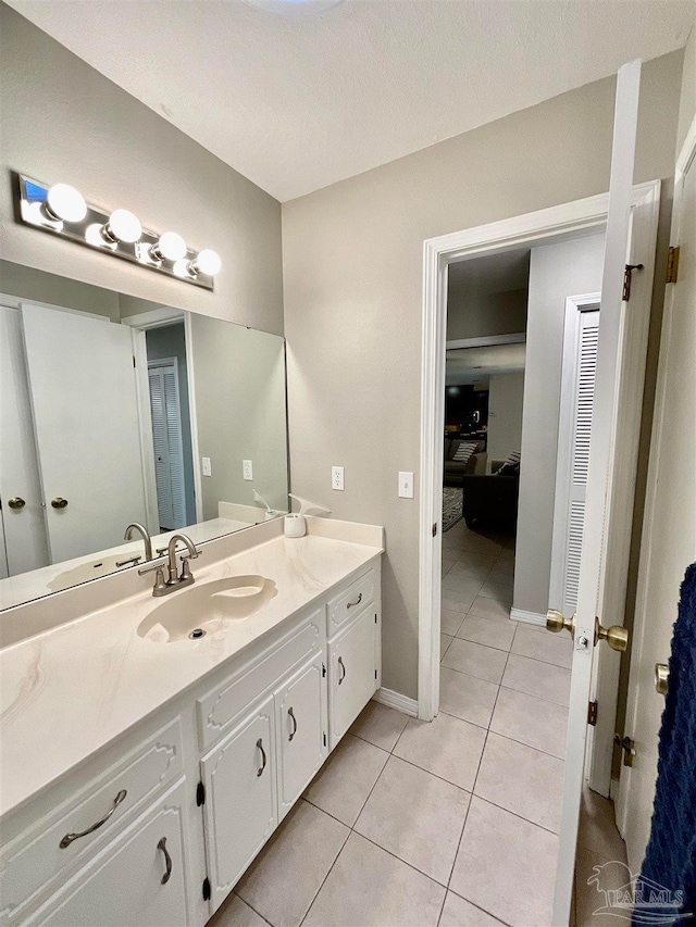 bathroom with tile patterned flooring, vanity, and a textured ceiling