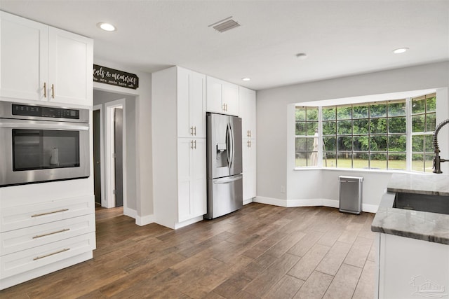 9852 Hillview Dr, Pensacola, FL 32514 - kitchen with stainless steel appliances, baseboards, a sink, white cabinets, and recessed lighting