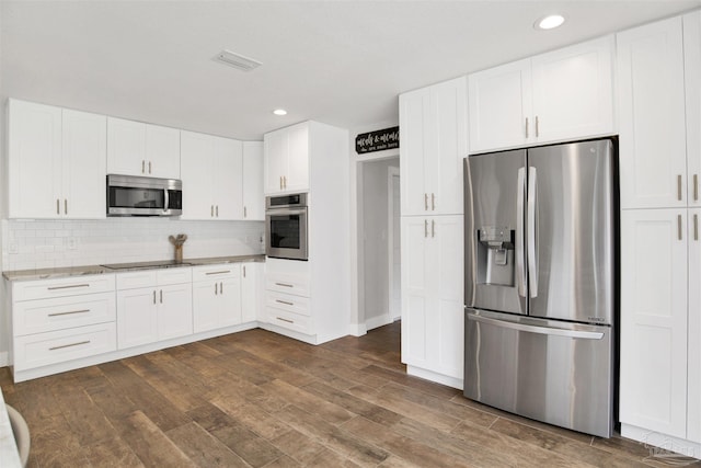 9852 Hillview Dr, Pensacola, FL 32514 - kitchen with stainless steel appliances, dark wood-style floors, recessed lighting, tasteful backsplash, and white cabinets