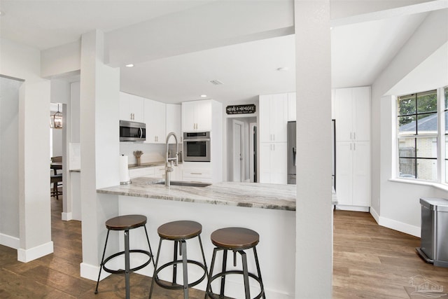 9852 Hillview Dr, Pensacola, FL 32514 - kitchen featuring appliances with stainless steel finishes, a sink, baseboards, a breakfast bar area, and recessed lighting