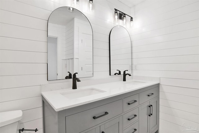 9852 Hillview Dr, Pensacola, FL 32514 - bathroom featuring double vanity, toilet, and wooden walls