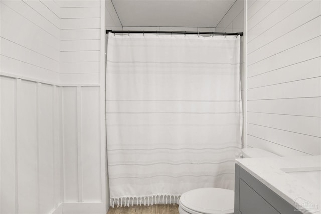 9852 Hillview Dr, Pensacola, FL 32514 - full bathroom with toilet, vanity, a shower with shower curtain, and wood finished floors