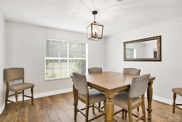 9852 Hillview Dr, Pensacola, FL 32514 - dining area with baseboards, a chandelier, and wood finished floors