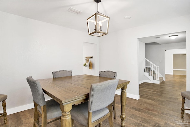 9852 Hillview Dr, Pensacola, FL 32514 - dining space with a chandelier, stairs, wood finished floors, and baseboards