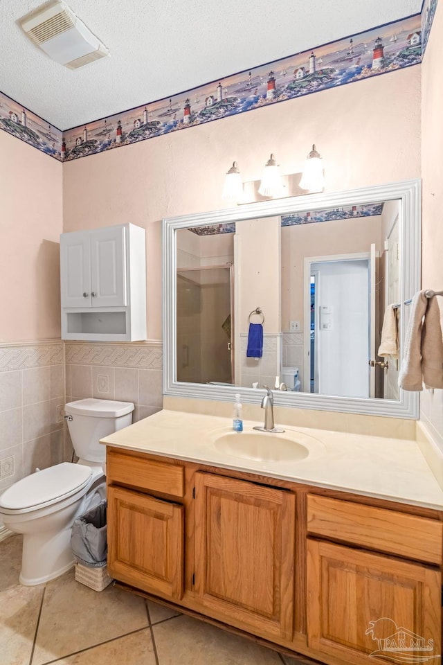 bathroom with vanity, tile patterned flooring, visible vents, toilet, and a stall shower