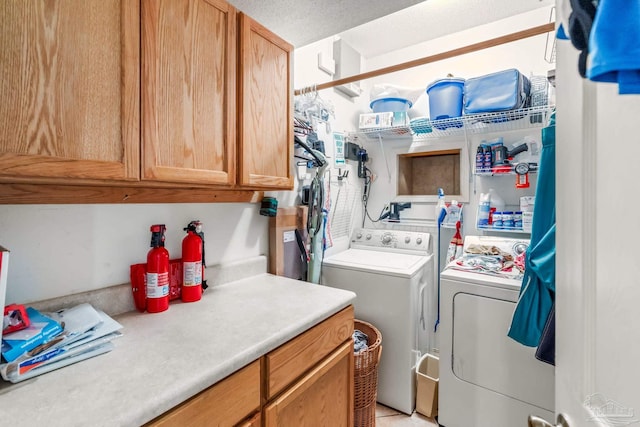 clothes washing area with cabinet space and washer and clothes dryer