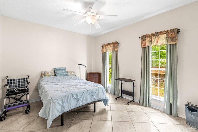 bedroom featuring light tile patterned floors, baseboards, and a ceiling fan
