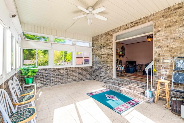 unfurnished sunroom featuring ceiling fan