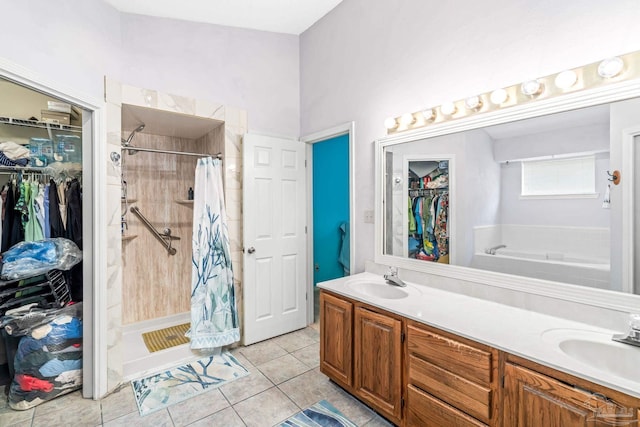 full bathroom with tile patterned flooring, double vanity, a sink, and a stall shower