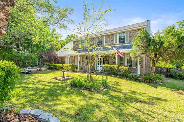 view of front of house with a front yard and brick siding