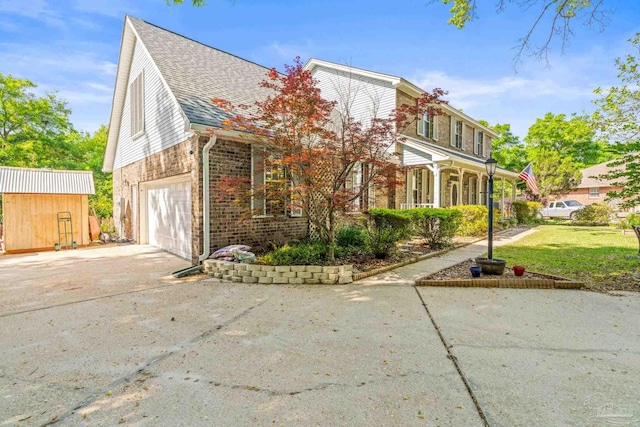 view of front of house with concrete driveway, a front yard, brick siding, a garage, and a shingled roof