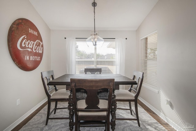 dining area with dark wood-type flooring and baseboards