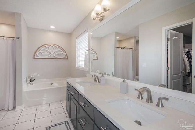 bathroom featuring tile patterned floors, a bath, and vanity