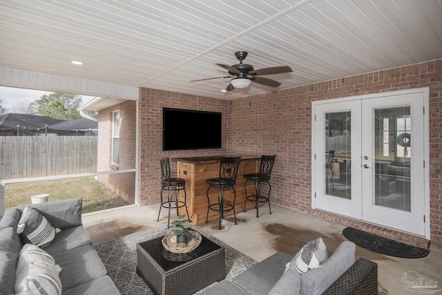 view of patio / terrace featuring french doors, ceiling fan, exterior bar, and outdoor lounge area