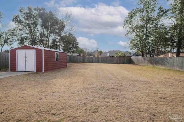 view of yard featuring a fenced backyard, a storage unit, and an outdoor structure