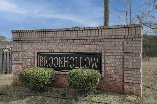 community / neighborhood sign featuring fence