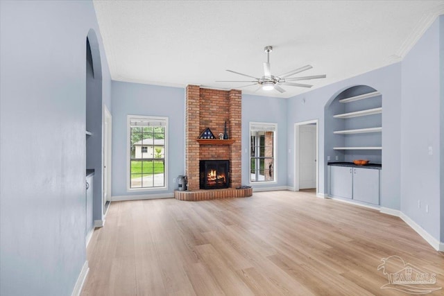 2574 1st Ct, Navarre, FL 32566 - unfurnished living room with a fireplace, built in features, a ceiling fan, baseboards, and crown molding
