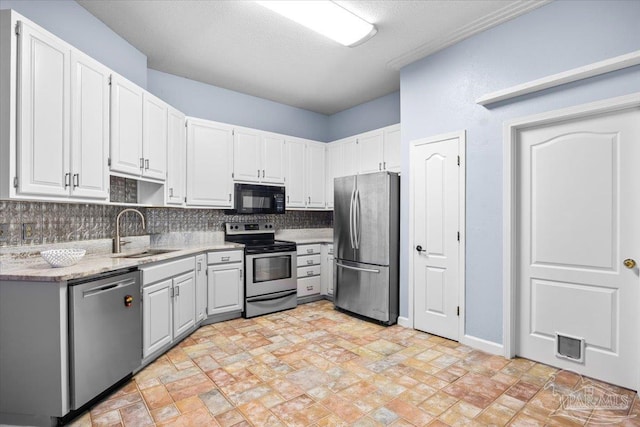 2574 1st Ct, Navarre, FL 32566 - kitchen with appliances with stainless steel finishes, a sink, tasteful backsplash, light stone countertops, and white cabinets