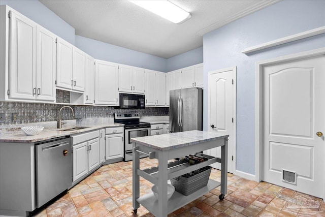 2574 1st Ct, Navarre, FL 32566 - kitchen with appliances with stainless steel finishes, a sink, backsplash, light stone counters, and white cabinets