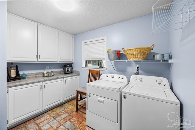 2574 1st Ct, Navarre, FL 32566 - laundry area with washer and clothes dryer, cabinet space, a textured ceiling, and stone finish flooring