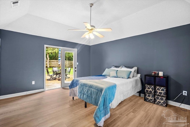 2574 1st Ct, Navarre, FL 32566 - bedroom featuring access to exterior, wood finished floors, a textured ceiling, lofted ceiling, and baseboards