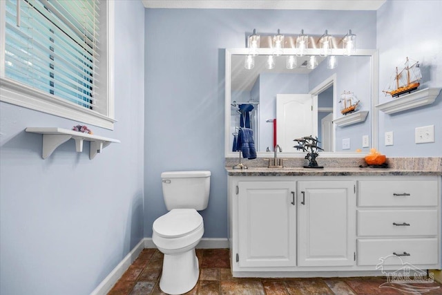 2574 1st Ct, Navarre, FL 32566 - bathroom featuring vanity, toilet, baseboards, and stone finish floors
