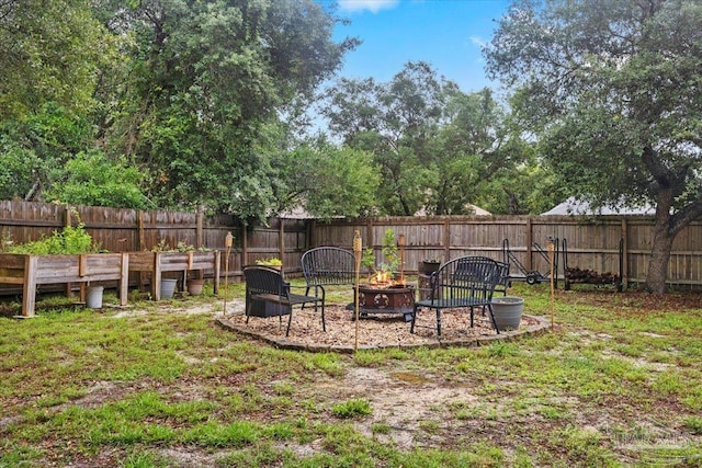 2574 1st Ct, Navarre, FL 32566 - fenced backyard featuring an outdoor fire pit