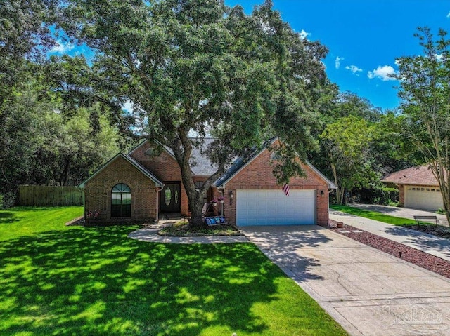 2574 1st Ct, Navarre, FL 32566 - view of front facade featuring an attached garage, concrete driveway, a front lawn, and brick siding