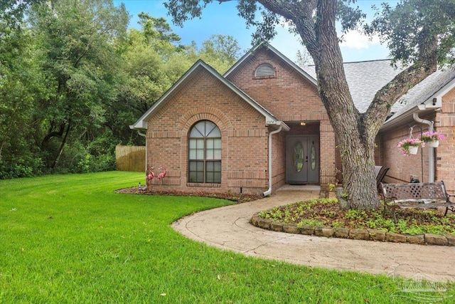 2574 1st Ct, Navarre, FL 32566 - view of front of house featuring a front yard, brick siding, and a shingled roof