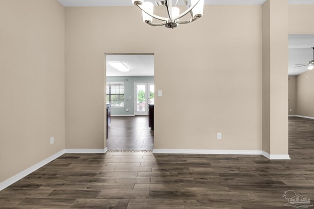 interior space with dark wood-type flooring and ceiling fan with notable chandelier