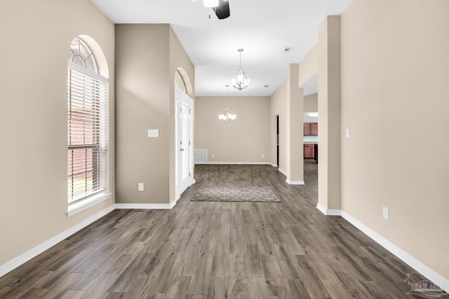 interior space featuring ceiling fan with notable chandelier and wood-type flooring