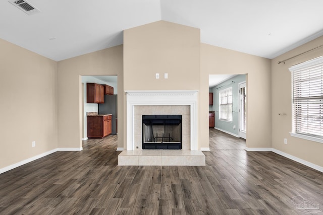 unfurnished living room featuring a fireplace, wood-type flooring, and vaulted ceiling