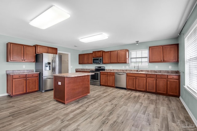 kitchen with a center island, light hardwood / wood-style flooring, appliances with stainless steel finishes, and sink