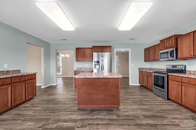 kitchen featuring an inviting chandelier, a kitchen island, appliances with stainless steel finishes, and dark hardwood / wood-style flooring