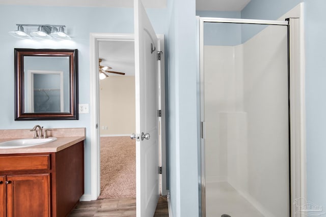 bathroom with vanity, wood-type flooring, ceiling fan, and walk in shower