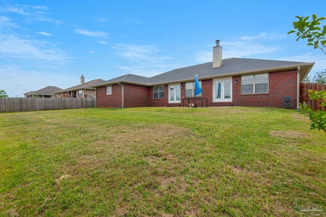 back of house featuring a lawn