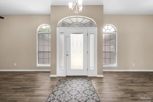 foyer entrance featuring dark hardwood / wood-style floors and a notable chandelier