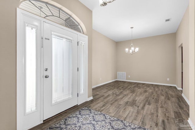 foyer with hardwood / wood-style flooring and an inviting chandelier