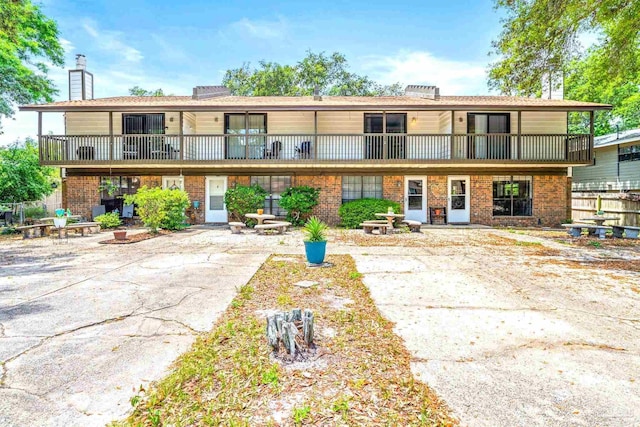 5791 Coronada Blvd Apt 3, Pensacola, FL 32507 - rear view of house with brick siding, a balcony, and a chimney