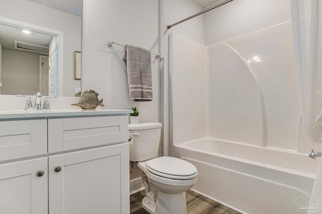 full bathroom with shower / washtub combination, hardwood / wood-style floors, vanity, and toilet