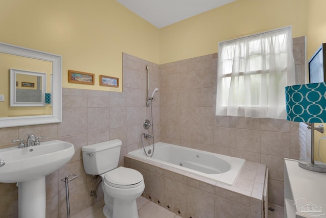 full bathroom with tile walls, tiled shower / bath combo, toilet, sink, and tile patterned floors