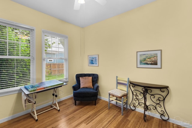 living area featuring light hardwood / wood-style floors and ceiling fan