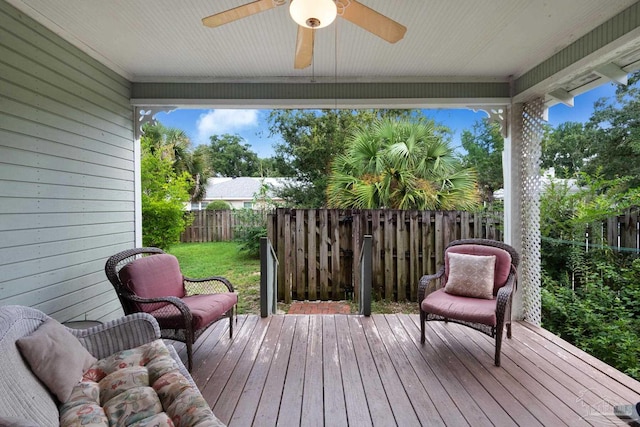 wooden deck with ceiling fan and a yard