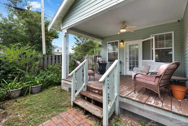 wooden deck featuring grilling area and ceiling fan