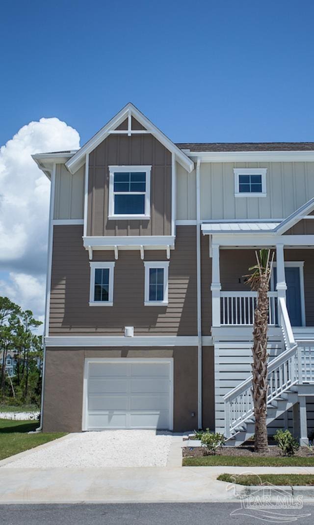 coastal inspired home featuring board and batten siding, driveway, stairs, and a garage