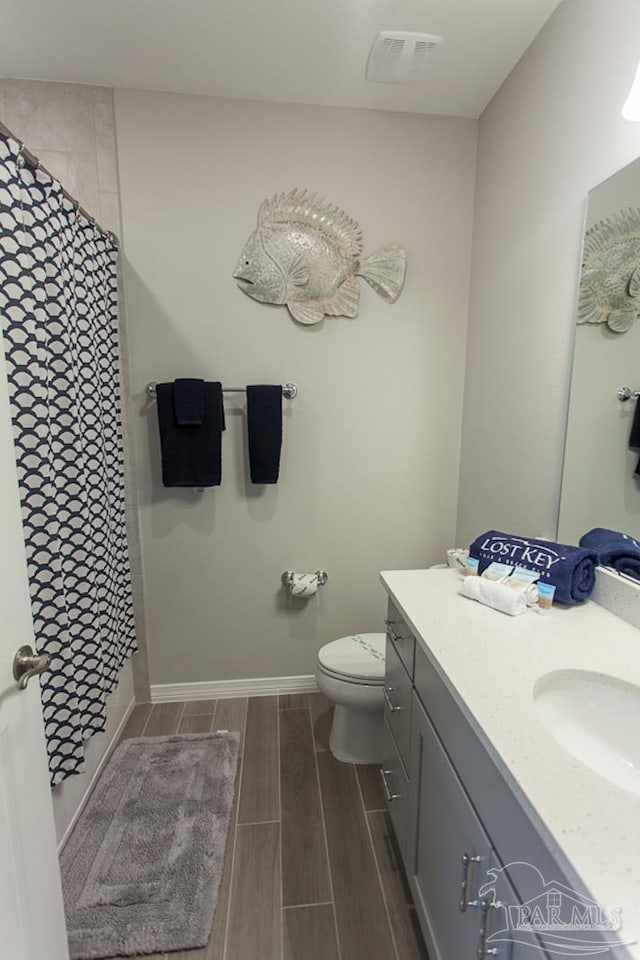 full bathroom with wood tiled floor, toilet, vanity, a shower with curtain, and baseboards