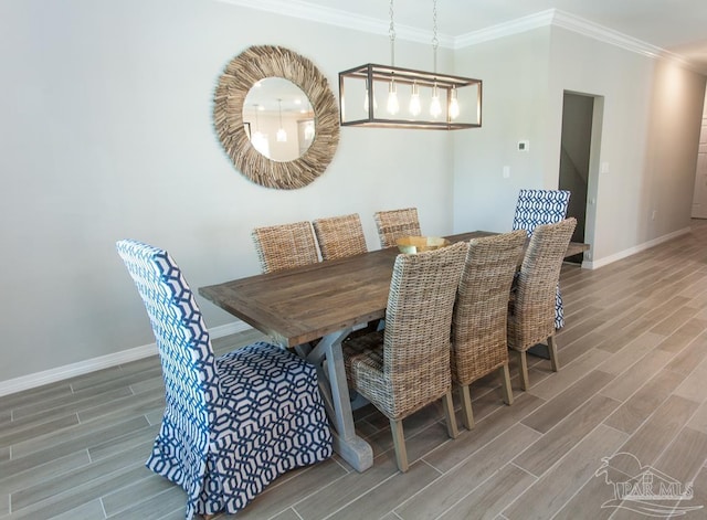 dining space featuring baseboards, crown molding, and wood finished floors