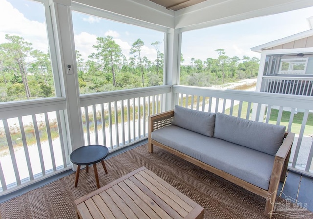 sunroom with an outdoor hangout area, a healthy amount of sunlight, and a water view