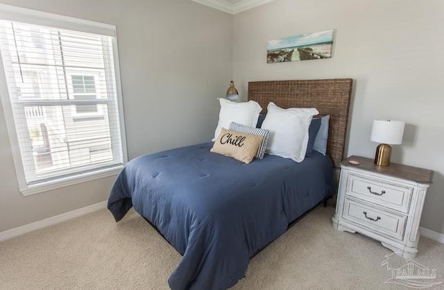 bedroom with light carpet, crown molding, and baseboards
